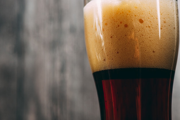 Close-up of a glass of foam dark lager beer