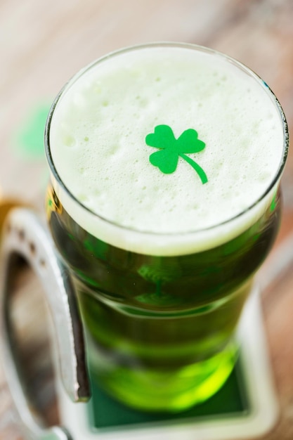 Foto vicino a un bicchiere di birra verde con ciambella