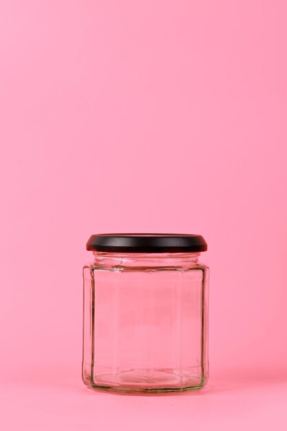 Close-up of glass jar against pink background