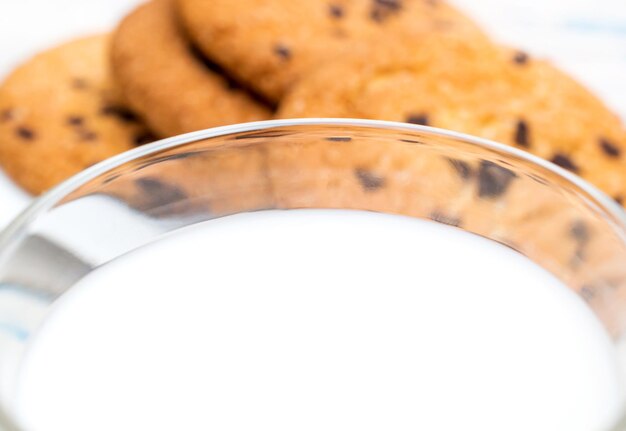 Close up of glass of milk on chocolate cookies background