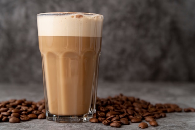 Фото Крупным планом стакан капучино с кофе в зернах