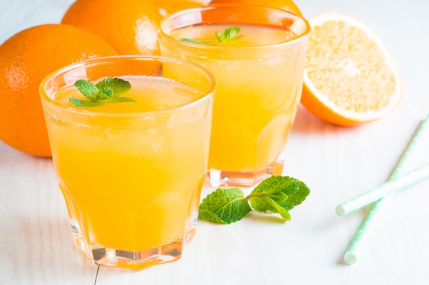 Close-up of a glass of orange juice with oranges fruits 