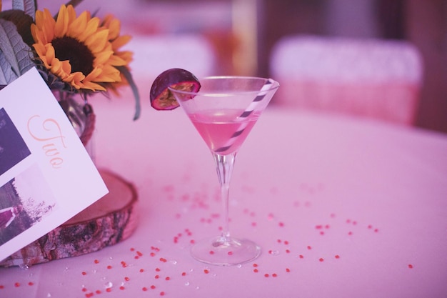 Photo close-up of glass of pink flower on table