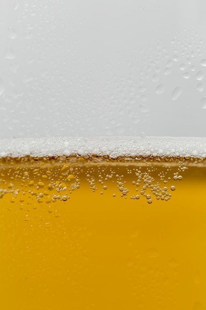 Photo close-up glass of refreshing beer with foam