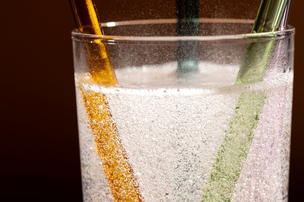 Close-up of glass straws in transparent fizzy liquid