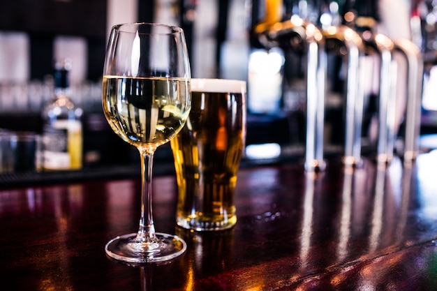 Primo piano di un bicchiere di vino e una birra in un bar