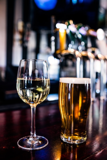 Primo piano di un bicchiere di vino e una birra in un bar