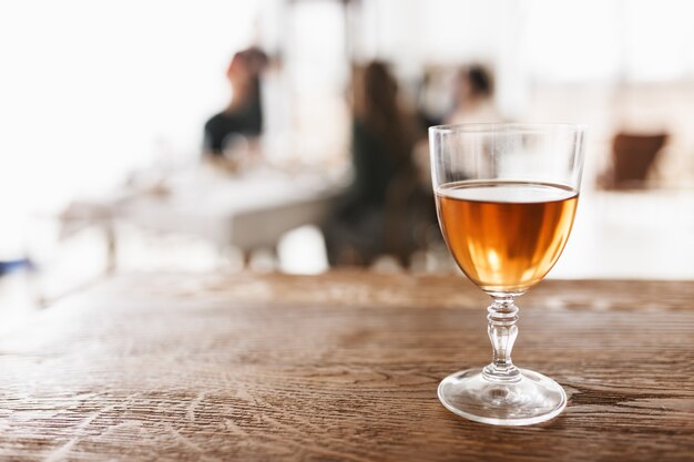 Close up glass of wine on wood table in cozy kitchen with fuzzy background isolated