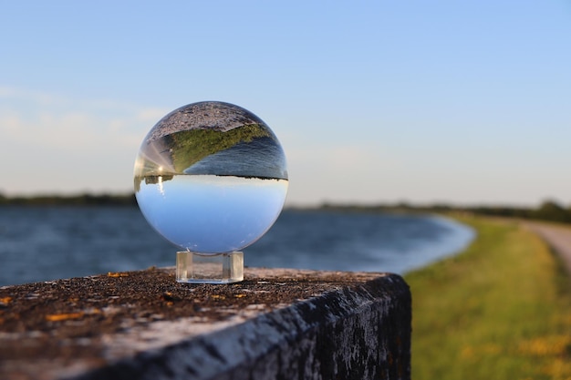 Foto close-up di una palla di vetro davanti a un fiume