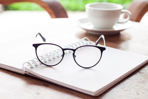 Photo close-up of glasses and book on table