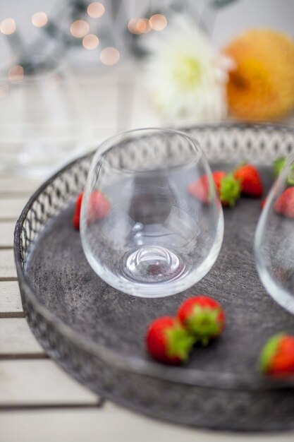 Foto close-up di bicchieri con fragole in piatto su tavola