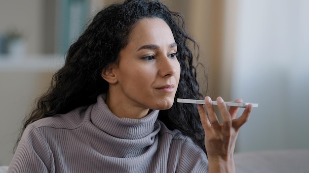 Close-up glimlachende gelukkige jonge vrouw praat op luidspreker opnemen audioboodschap met behulp van de telefoon