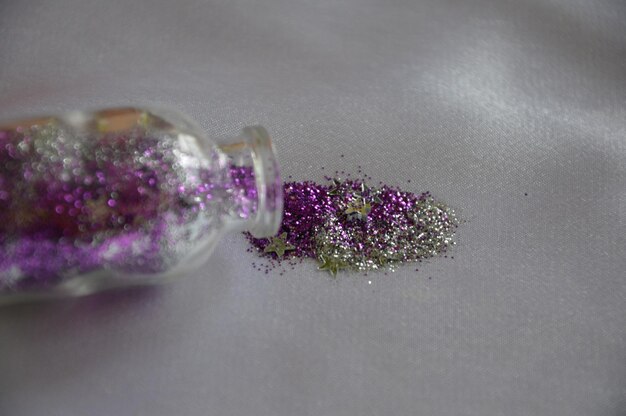 Photo close-up of glitter with bottle on paper