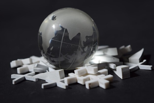 Photo close-up of globe amidst crosses on black background