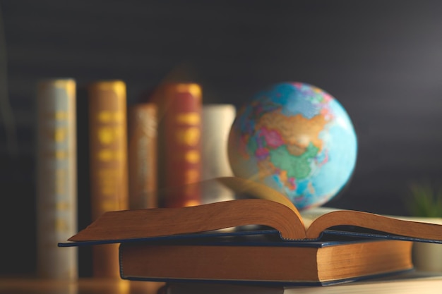 Photo close-up of globe on book over table