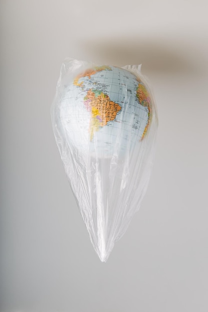 close-up of globe in plastic bag against gray background
