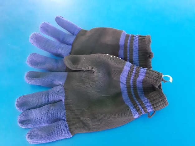 Close-up of gloves against blue background