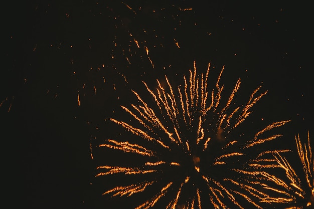 Фото Крупным планом золотой праздничный фейерверк на черном