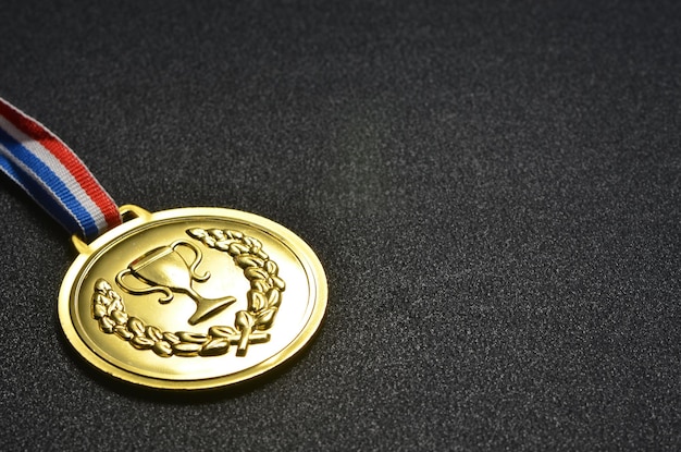 Close-up of gold medal on black table