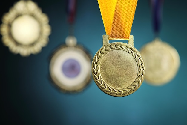 Photo close-up of gold medals hanging against blackboard
