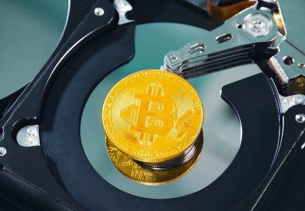 Close up golden bitcoin place on the platter of hard disk drive insidecryptocurrency concept