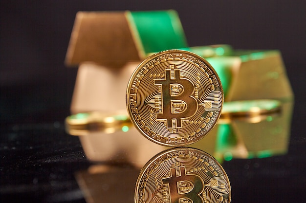 Close-up golden bitcoin on the reflective desk.