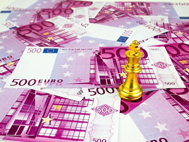 Foto close-up del re d'oro degli scacchi sulle banconote da cinquecento euro a tavola