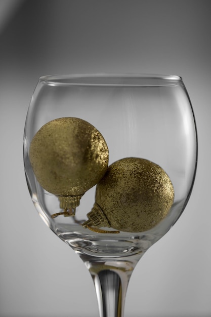 Close-up of golden christmas ornaments in wineglass