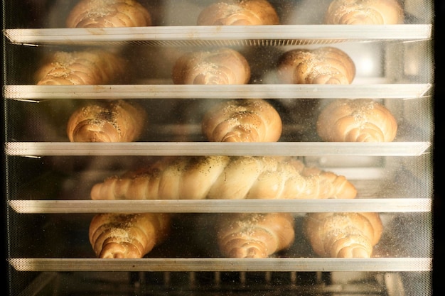 Foto primo piano di pane fresco dorato che lievita nel forno nello spazio della copia della cucina del panificio