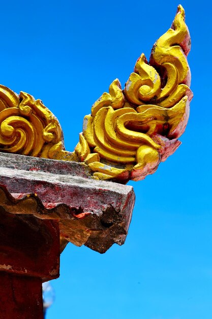 Close-up of golden roof sculpture against clear sky