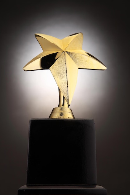 Photo close-up of golden star shape trophy against black background