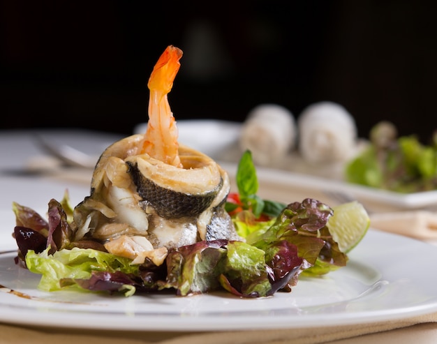 Закройте вверх по изысканному рецепту аппетитных свежих морепродуктов на овощах. Подается на стол в ресторане во время ужина.