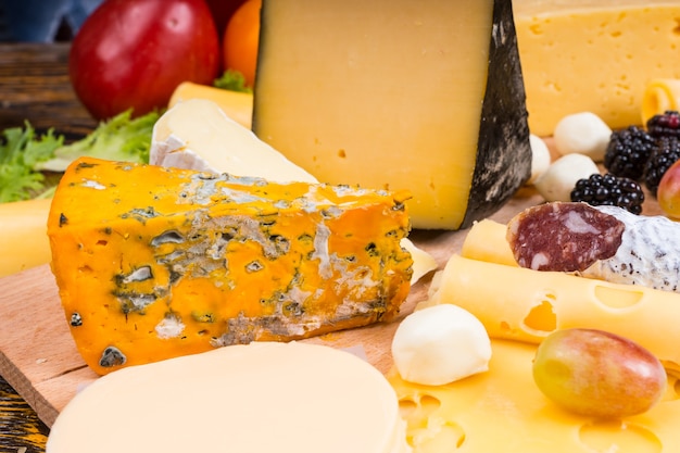 Close Up of Gourmet Cheese Board Featuring Variety of Cheeses, Cured Meats and Garnished with Fresh Fruit