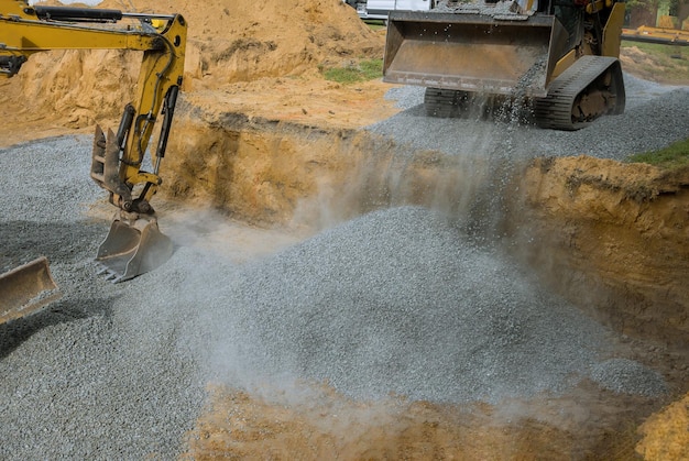 Close-up graafmachine werkt op een bouwplaats graafmachinebak niveaus grind in het gebouw