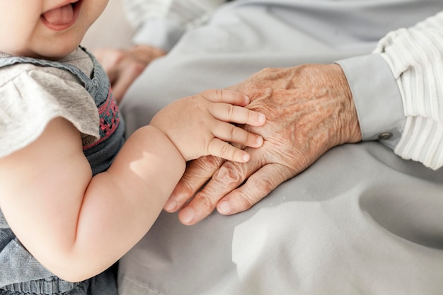 Nipote del primo piano che tiene la mano delle nonne