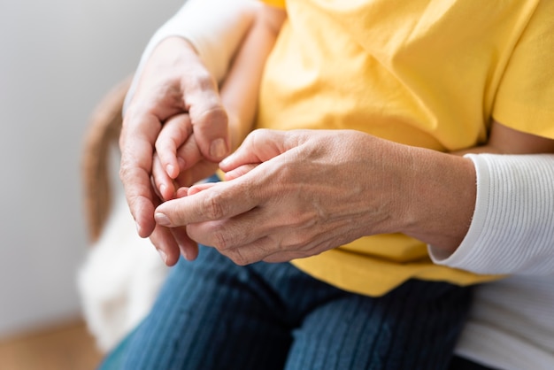 Close up grandparent holding kids hands