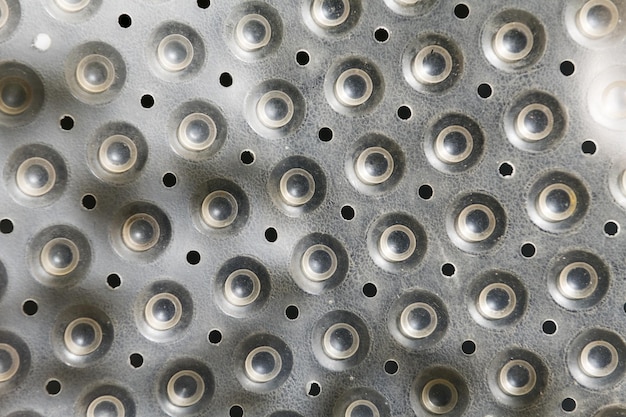 A close up of a grater with holes in it