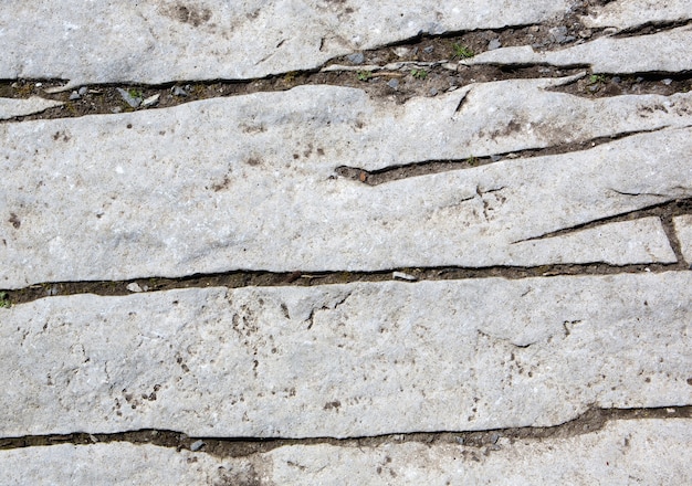 Close up gray rock cracked and weathered with lines