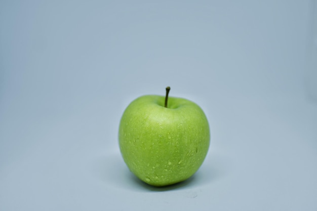 Close-up of green apple against blue background