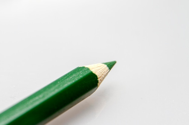 Клоуз-ап зеленого карандаша на белом фоне