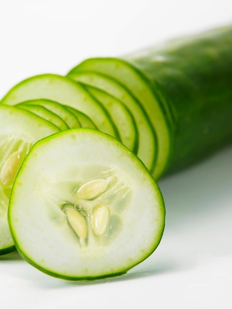 Foto close-up di una fetta di cetriolo verde su uno sfondo bianco