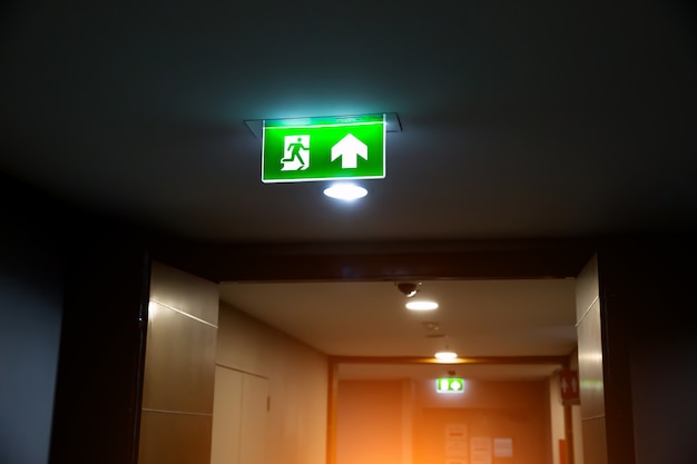 Close up the green fire exit sign with the door exit.