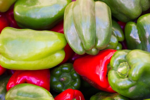 Foto chiuda in su sui peperoni verdi e rossi. ortaggi freschi e biologici sulla bancarella del mercato