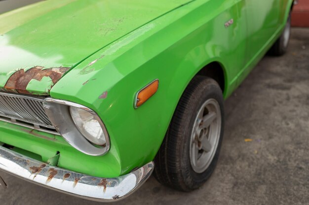 Close-up of green toy car on street in city