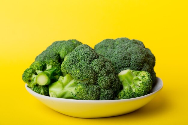 Close-up of green vegetables in bowl against yellow background