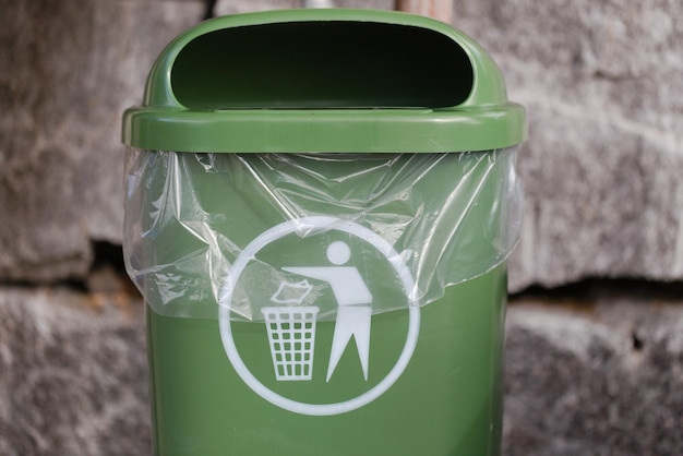 Photo close-up of green warte bin against wall