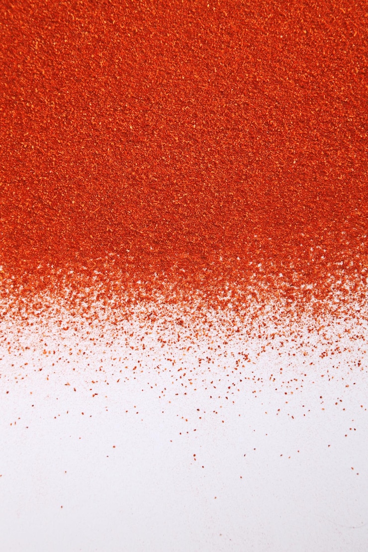 Photo close-up of ground red chili pepper over white background