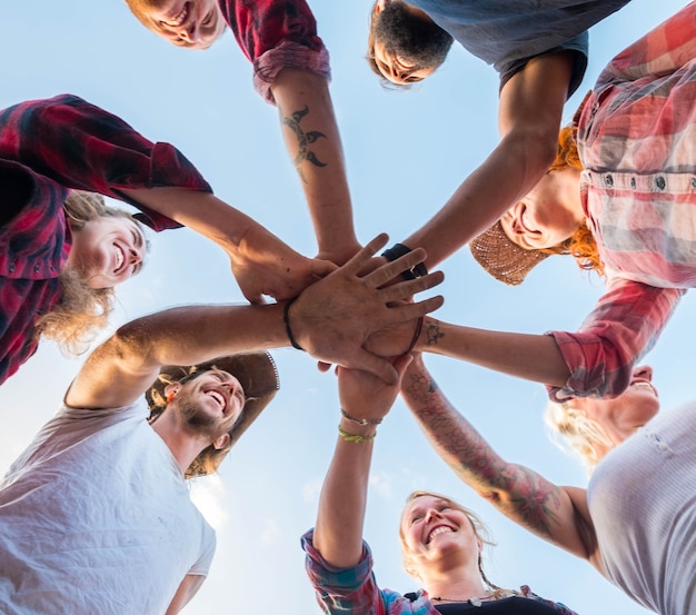 Photo close up of group of adults with their hands in the middle - union and team workers - ground view