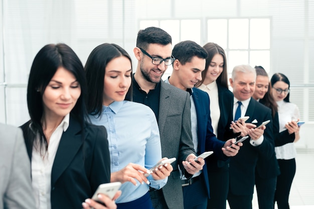 Close up. group of business people with smartphones standing in a row