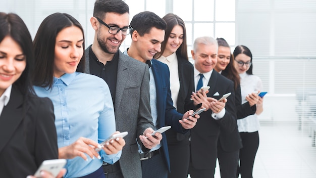 Close up. group of business people with smartphones standing in a row